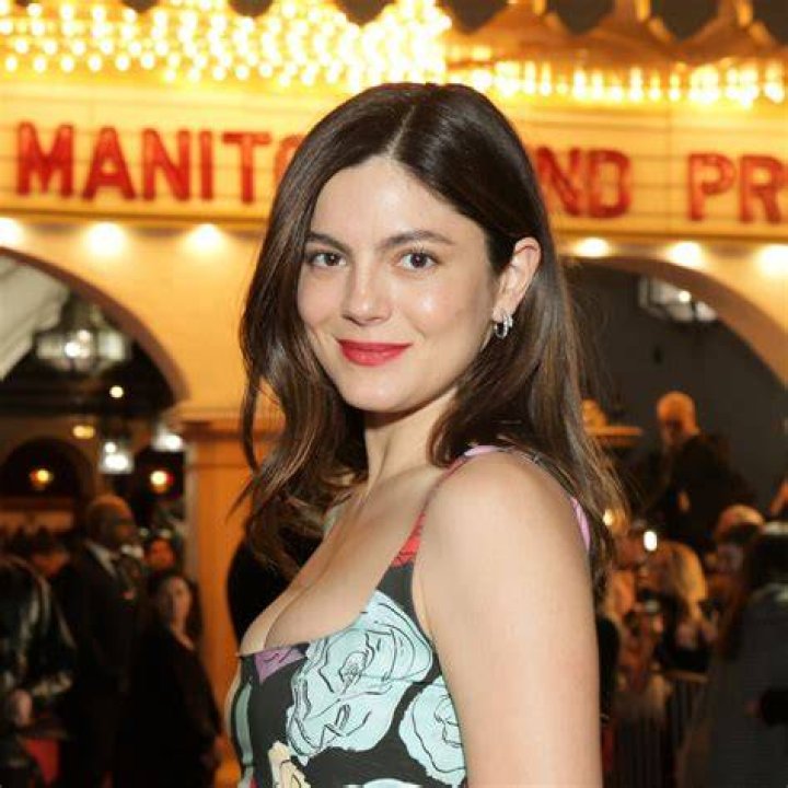 Monica Barbaro flashes her cleavage in a racy blue and maroon gown at